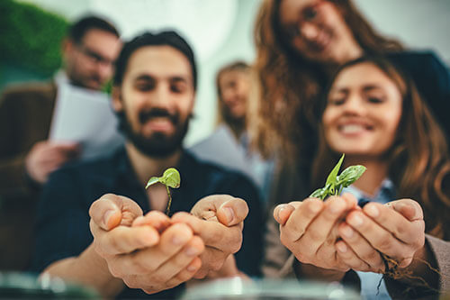 My Jopportunity - Glückliche Menschen aus der Landwirtschaft halten Pflanze in Kamera